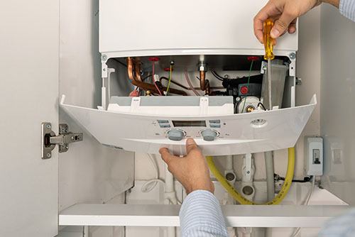 HVAC technician repairing an indoor boiler in Sun City West