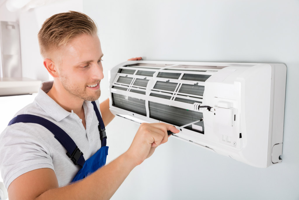 HVAC technician performing ductless air conditioning maintenance in Sun City West