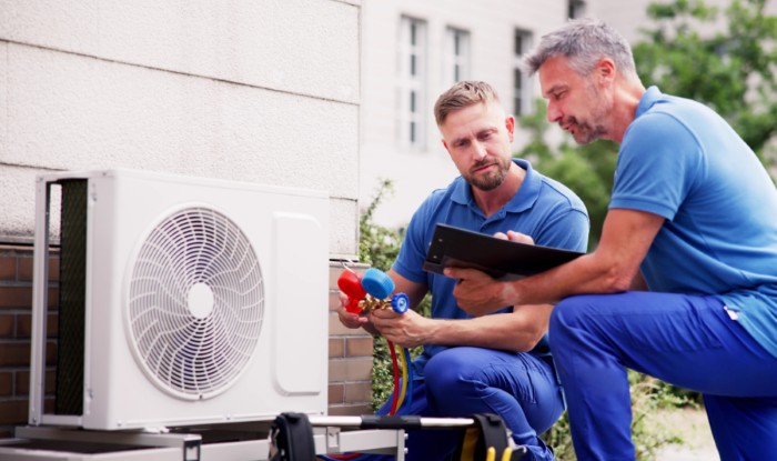 HVAC technicians installing an outdoor air conditioning unit in Sun City West