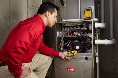 Heating and air conditioning technician servicing an indoor furnace in Sun City West, AZ